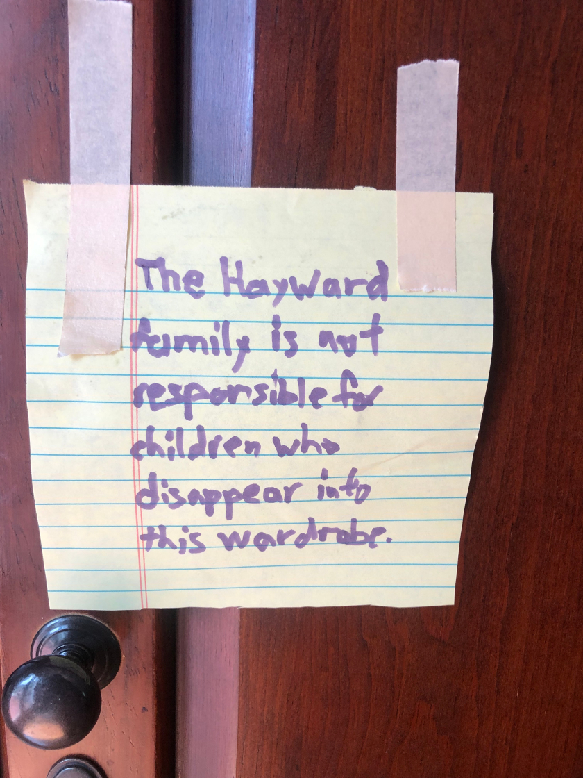 A notice on the wardrobe that says, "The Hayward family is not responsible for children who disappear into this wardrobe.