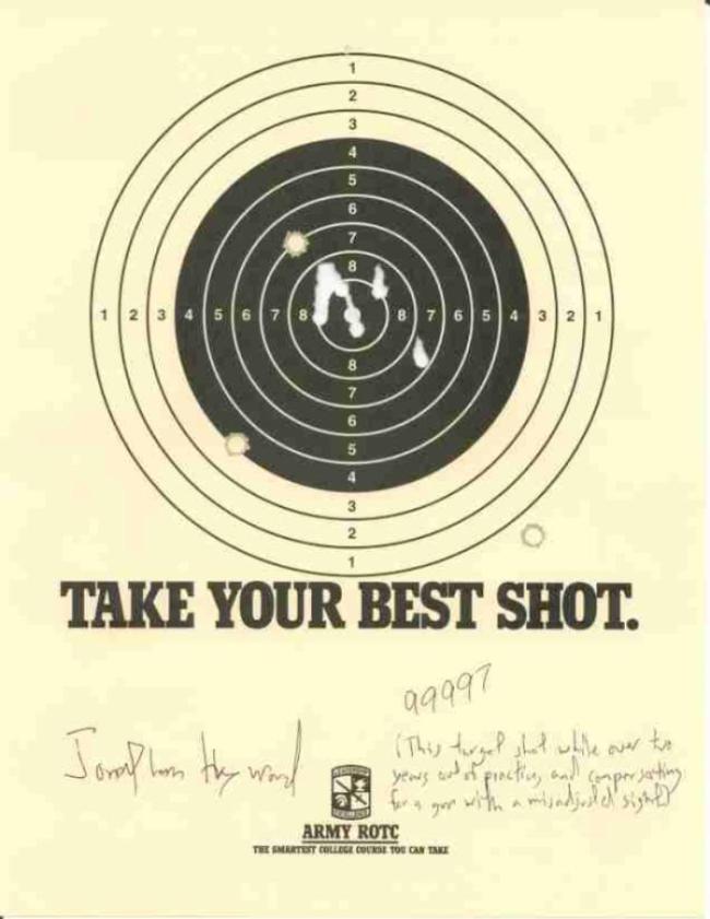 A rifle target with five holes.