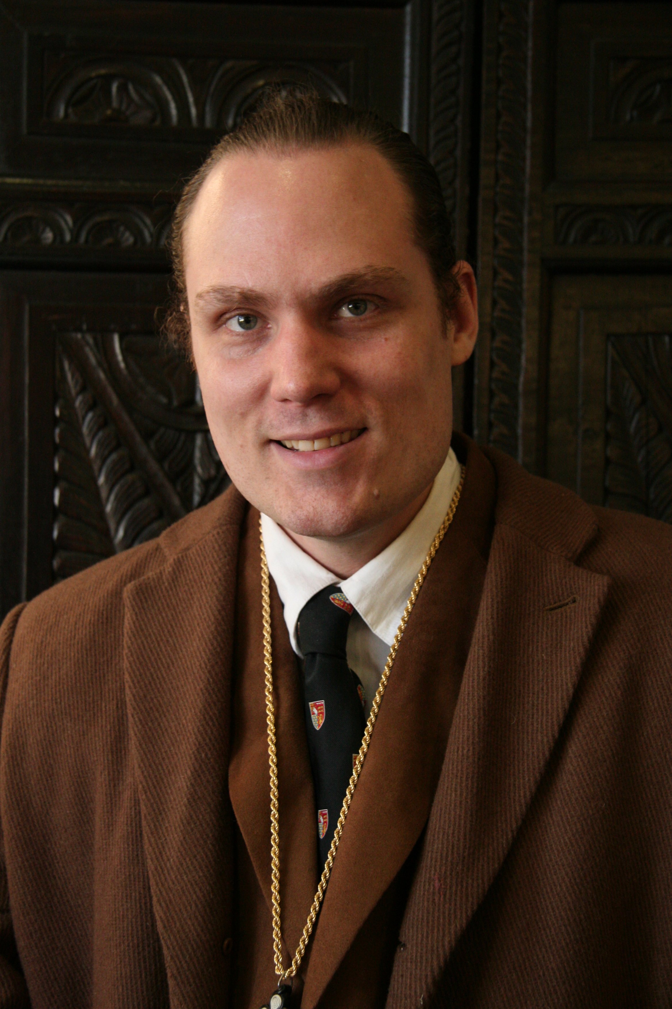 A picture of C.J.S. Hayward standing in front of the wardrobe believed to have inspired C.S. Lewis's 